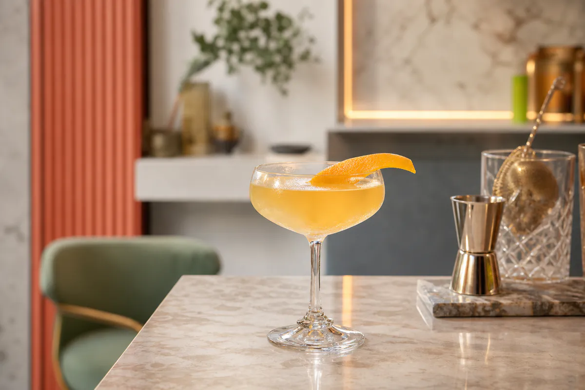 Eleganter Cocktail mit Zitrusfrucht in einer hellen, modernen Bar